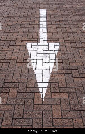 White arrow painted on the road, straight ahead concept. Stock Photo