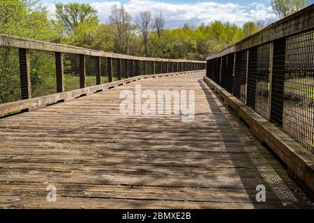 Low angle view of a pedestrain footbridge in Elm Creek Park Reserve along the trails on a spring day in Maple Grove Minnesota Stock Photo