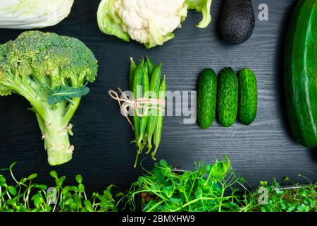 Variety of green vegetables on wooden background, broccoli, avocado, micro sprouts, peas, salad, zucchini, cucumber, cauliflower, cabbage, flat lay. D Stock Photo