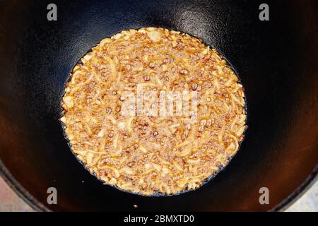 National Uzbek dish pilaf, pilaw, plov, rice with meat in big pan. Cooking process, open fire. Cooking in a cauldron on fire. .Preparation stages Stock Photo