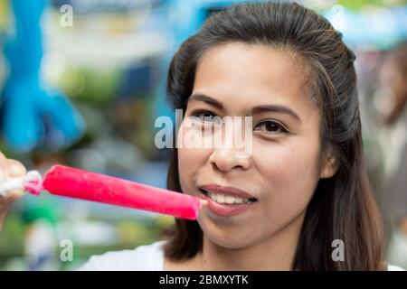 Woman holding red ice cream in hand. Stock Photo