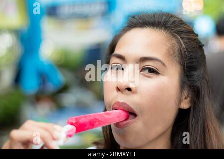 Woman holding red ice cream in hand. Stock Photo