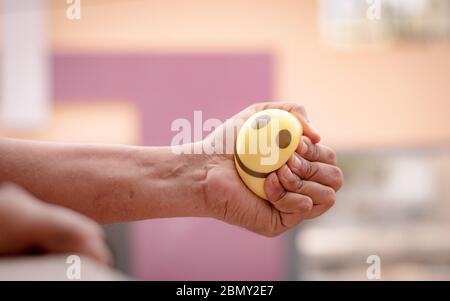 Hands squeezing or pressing stress ball at home to release stress - concept of stress buster Stock Photo