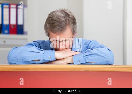 Mature businessman sleeping at a desk in an office - selective focus Stock Photo