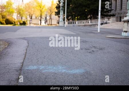 stay home message written with blue chalk on a pathway in Vienna Stock Photo