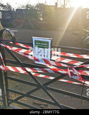 London, United Kingdom - March 31, 2020: Red and blue tape barrier parts of local park closed due to coronavirus covid-19. Entering many public places Stock Photo