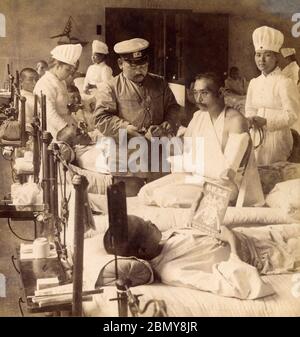 [ 1904 Japan - Red Cross Hospital during the Russo-Japanese War ] —   Japanese Red Cross nurses and a doctor attending to wounded soldiers at Kojimachi Hospital (麹町病院), Tokyo during the Russo-Japanese War (1904-1905), ca.1904. Stock Photo