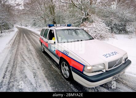 Hampshire Constabulary marked police cars on patrol in the Lyndhurst area of the New Forest during a winter snow fall, Lyndhurst, New Forest, Hampshire, England, UK Stock Photo