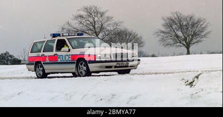 Hampshire Constabulary marked police cars on patrol in the Lyndhurst area of the New Forest during a winter snow fall, Lyndhurst, New Forest, Hampshire, England, UK Stock Photo