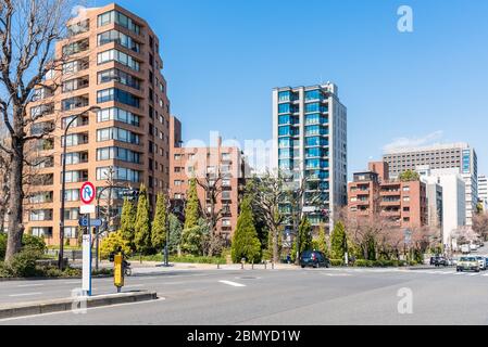 Apartment buildings in a residential district in Tokyio on a clear early spring day. An intersection with traffic lights is in foreground. Stock Photo