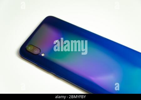 The back of a blue smartphone with two cameras and a flash, illuminated with colored light on a white background Stock Photo