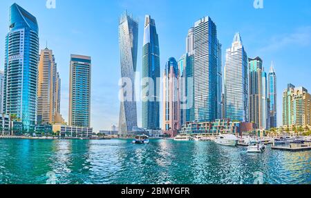 DUBAI, UAE - MARCH 2, 2020: Walk the promenade of Dubai Marina and watch its luxury skyscrapers, modern yachts, outdoor restaurants, on March 2 in Dub Stock Photo