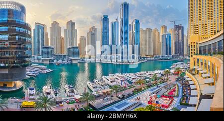 DUBAI, UAE - MARCH 2, 2020: Enjoy the sunset in Dubai Marina with a view on yachts of Marina Mall yacht club, Pier 7 building, cafes and restaurants a