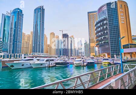 DUBAI, UAE - MARCH 2, 2020: The shipyard with moored yachts and boats at the building of posh Pier 7 restaurant complex, located in Dubai Marina, on M