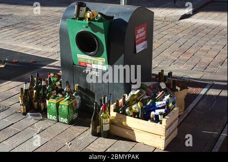 Discarded wine and beer bottles at a recycling deposit bin. The aftermath of COVID-19 confinement alcohol consumption. Stock Photo