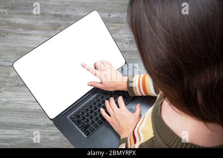 Woman working with her laptop with blank white touchscreen at home. Social distancing during quarantine. Stock Photo