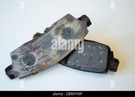 pair of worn out ruined disc brake pads Stock Photo