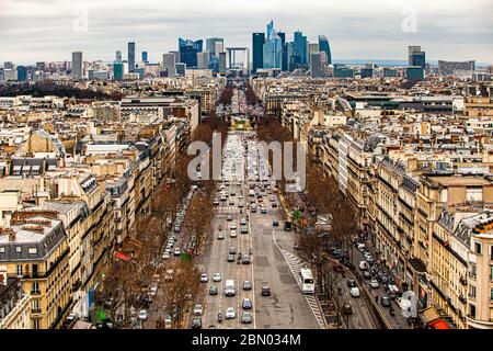 Wide view from the Arc de Triomphe in Paris over a circular traffic junction with a green island and heavy car traffic towards the La Défense business district. Taken on 17 February 2012. Stock Photo