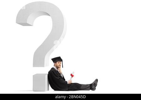 Male graduate student holding a diploma and leaning on a big question mark isolated on white background Stock Photo