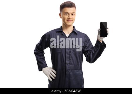 Young mechanic holding a mobile phone and pointing at it isolated on white background Stock Photo