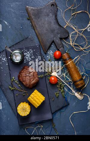 Beef Steak with a choper. Well done Steak with grilled vegetables. Top view, copy space. Stock Photo