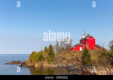 Red lighthouse on Lake Superior shore.  The historic Marquette Harbor Lighthouse in Marquette, Upper Michigan.  Room for copy if needed. Stock Photo