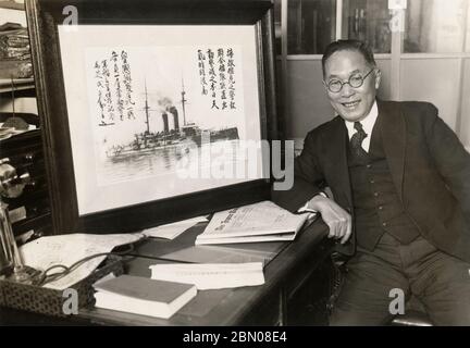 [ 1929 Japan - Kimpei Shiba and Battleship Mikasa ] —   Japan Times editor Kimpei Shiba (芝均平, 1903–1996) with a photo of the Imperial Japanese Navy battleship Mikasa, 1929 (Showa 4).  The Mikasa served as the flagship of Admiral Heihachiro Togo (東郷 平八郎, 1848–1934) during the Russo-Japanese War of 1904–1905 (Meiji 37–38).  Shiba was instrumental in saving the Mikasa from destruction in 1923 (Taisho 12). Following the Washington Naval Treaty (九カ国条約) of 1922, the ship was scheduled to be scrapped.  20th century gelatin silver print. Stock Photo