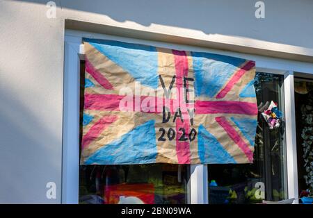 Colourful home-made Union Jack flag to celebrate VE Day, 8 May 2020, during llockdown in the window of a house in Surrey, south-east England Stock Photo
