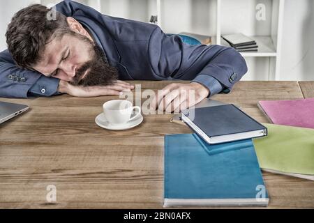 let me relax. Man sleeping over workplace. coffee will help me. bored and exhausted guy sleep at work. need break for relax. being lazy. Tired businessman sleep in office. boss fell asleep on table. Stock Photo