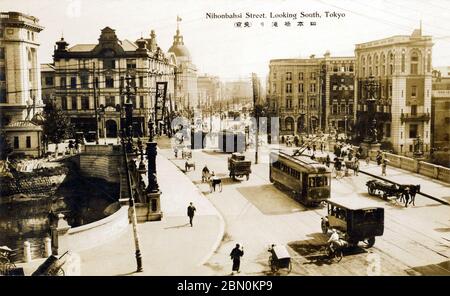 [ 1920s Japan - Nihonbashi Bridge, Tokyo ] —   Streetcars and other traffic cross the Nihonbashi Bridge in Tokyo. The photographer was pointing his camera to the south.  During the Edo Period (1600-1867), Nihonbashi  Bridge was the starting point of the famous Tokaido and the other 4 post roads.  The stone bridge with bronze lions and wrought-iron gas lamps on this image replaced the wooden one in 1911 (Meiji 44).  20th century vintage postcard. Stock Photo