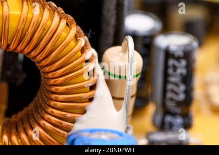 Old vintage printed circuit board with electronic components. Electronic Coil in the foreground. Closeup with shallow DOF . Stock Photo