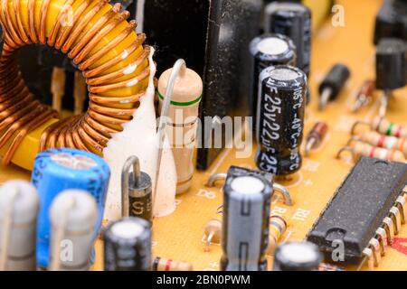 Old vintage printed circuit board with electronic components. Electronic Coil in the foreground. Closeup with shallow DOF . Stock Photo