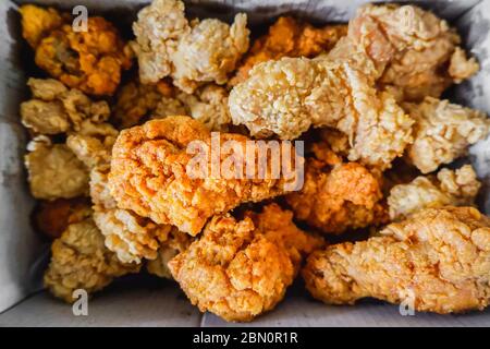 Above view of Crispy chicken drumsticks fired packed in a paper box for delivery or take home. Stock Photo