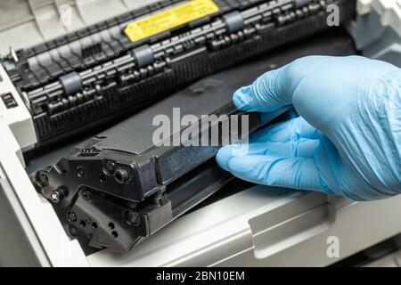 Refill and repair the printer cartridge. Gloved hand Stock Photo