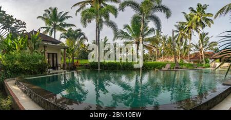 Pool view in Bali, Indonesia outside with green trees and blue skies Stock Photo