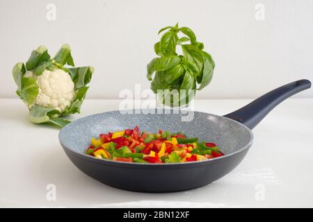 Frying pan and colorful vegetables on white background Stock Photo