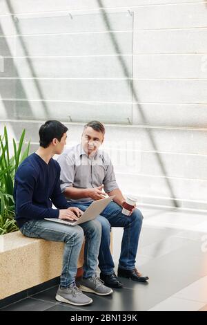 Serious multi-ethnic business people discussing project they are working on Stock Photo