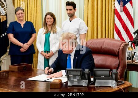 Washington, United States Of America. 06th May, 2020. President Donald J. Trump signs a proclamation in honor of National Nurses Day Wednesday, May 6, 2020, in the Oval Office of the White House. People: President Donald Trump Credit: Storms Media Group/Alamy Live News Stock Photo
