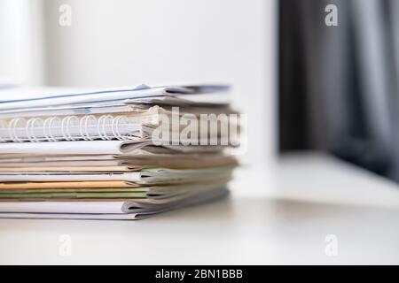 Stack of different notebooks on a white windowsill, in natural light from a window. Stock Photo
