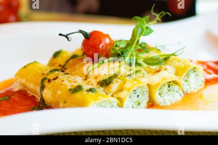 Cannelloni pasta tubes are stuffed with a rich and flavorful ricotta filling, then covered in marinara and a generous topping of mozzarella Stock Photo