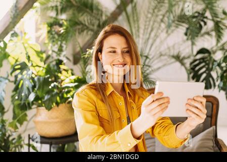 Young woman reading e-book on the couch. happy woman lie down on bed and playing smart tablet at home. Stock Photo