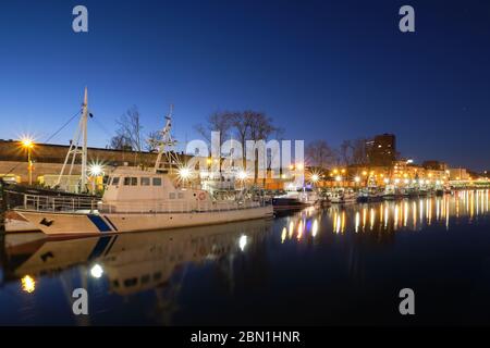 Pier for boats and yachts in Klaipeda, Lithuania, on sunset. Beautiful view of vessels and their reflections in calm water on blue hour Stock Photo