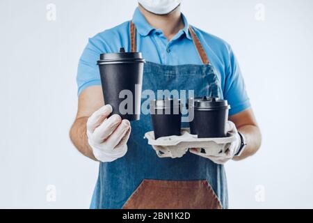 Unrecognizable man in blue polo with food delivery orders against grey background Stock Photo