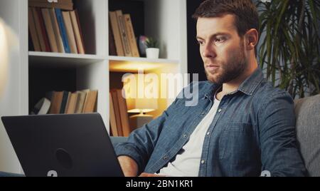 Man using laptop sitting couch Stock Photo