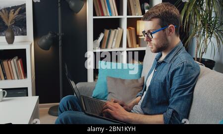 Man using laptop, side view Stock Photo