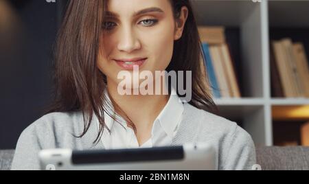 Brunette using tablet indoors, headshot Stock Photo