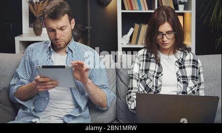 Couple using tablet and laptop Stock Photo
