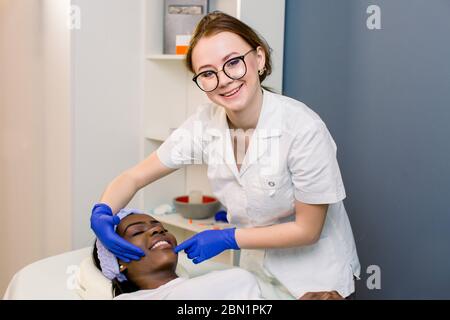 Beauty treatment results. Beautiful healthy cheerful woman smiling while her cosmetologist is examining her skin happiness vitality cosmetology beauty Stock Photo