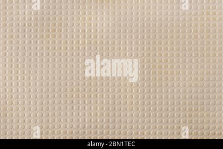 Beige faux leather with a pattern of evenly repeating small circles. A variety of textures of artificial materials. Background. Top view. Stock Photo