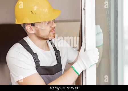 Worker in installing rubber seals on plastic upvc window Stock Photo